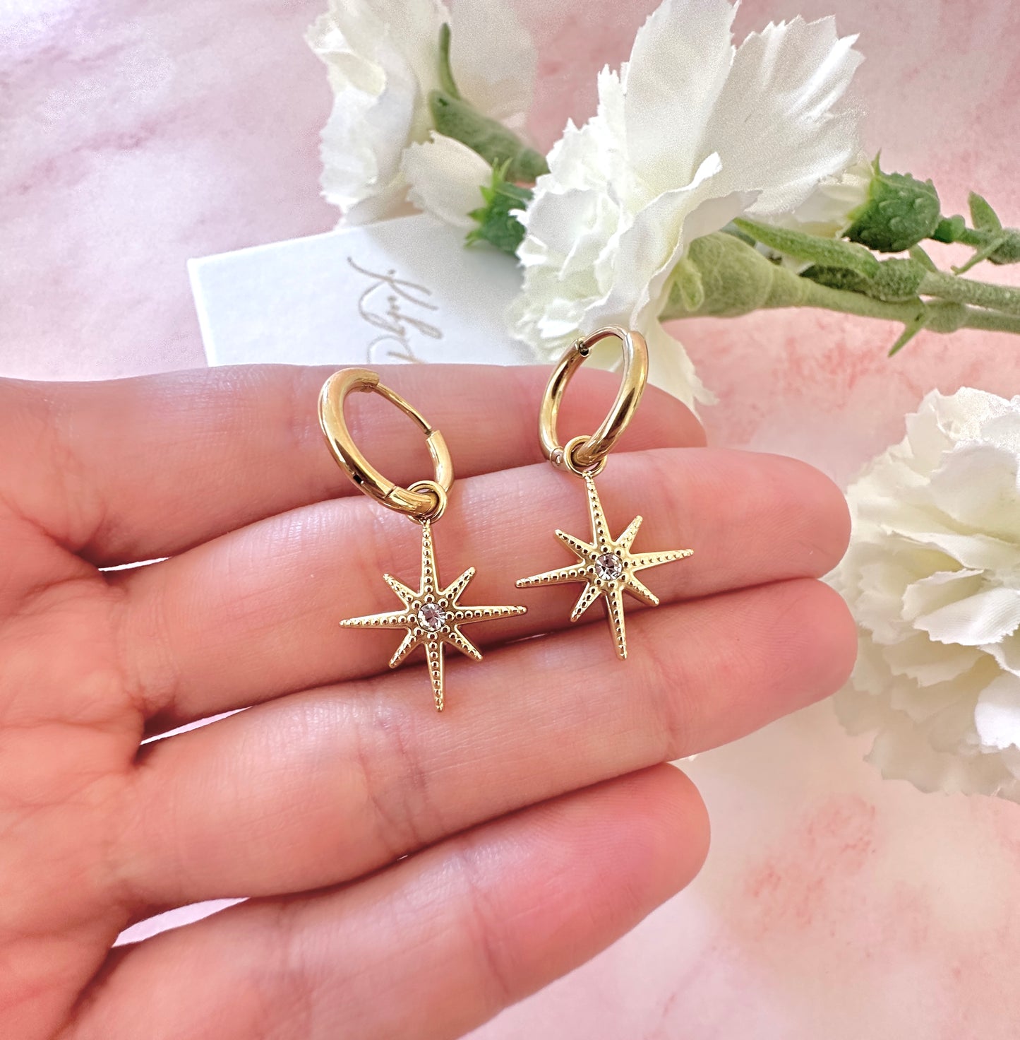 Gold CZ north star Huggie earrings.