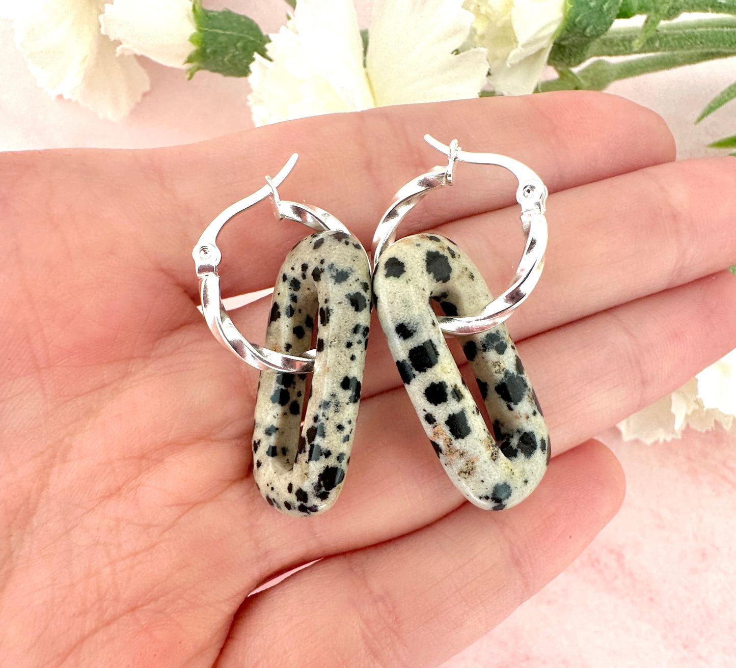 Silver Dalmatian Jasper gemstone twist hoop earrings.