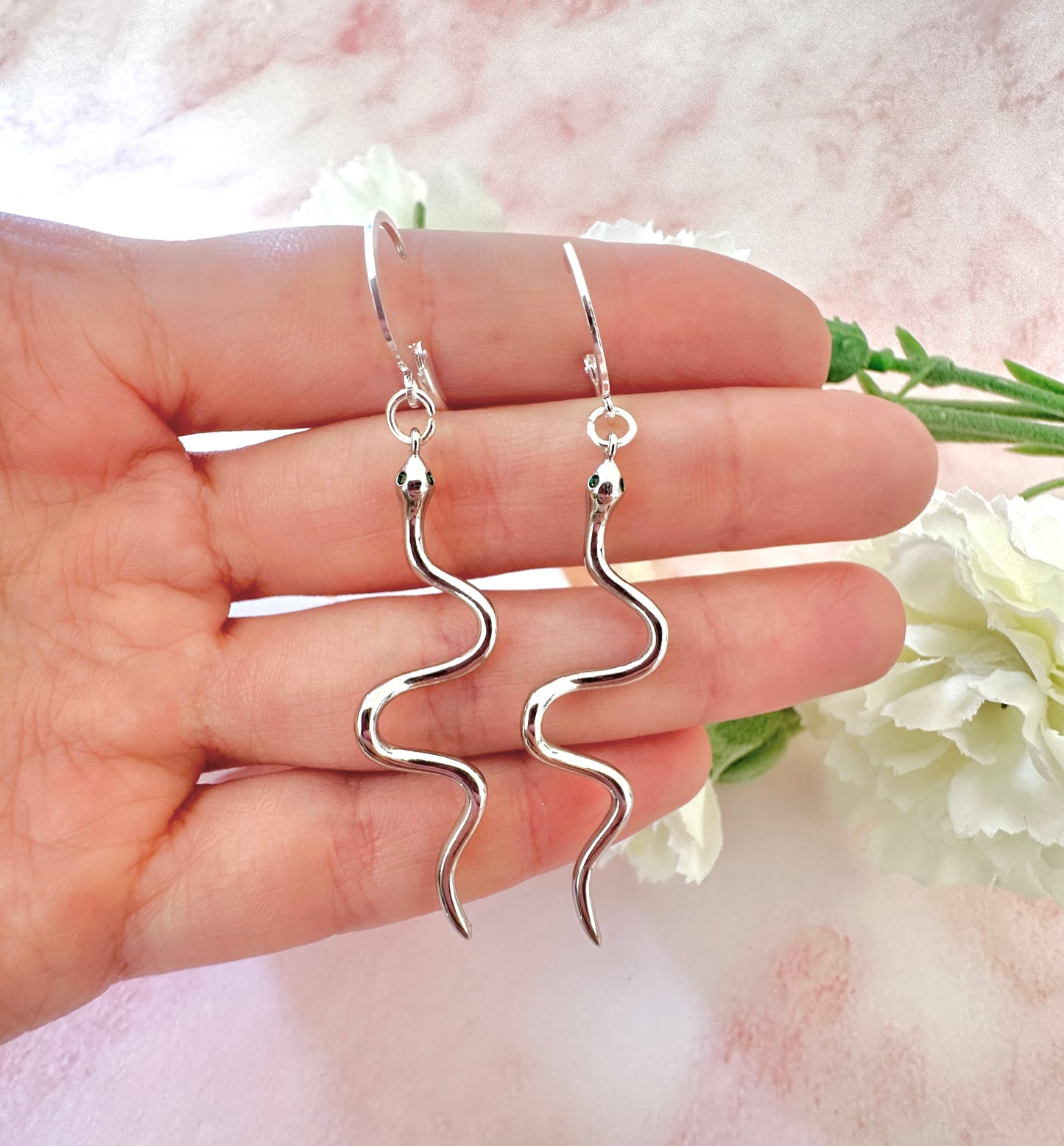 Silver snake Huggie earrings.