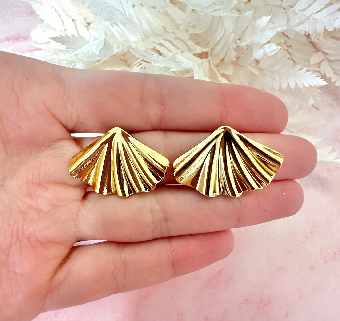 Gold Fan oversized stud earrings.