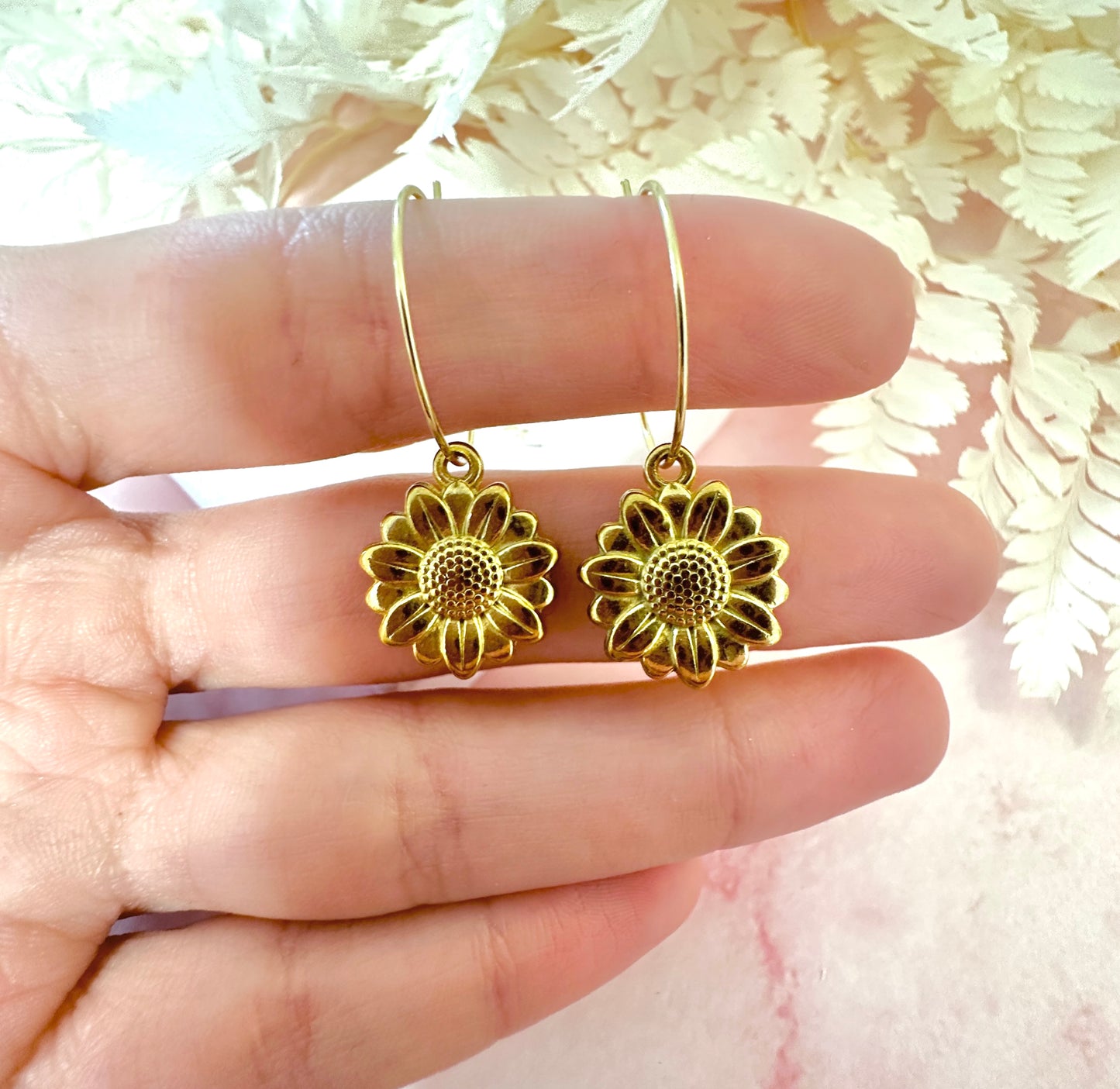 Gold sunflower hoop earrings.