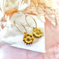 Gold sunflower hoop earrings.