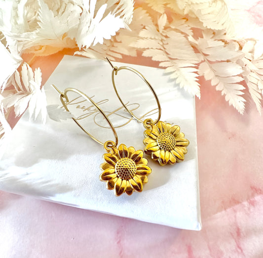 Gold sunflower hoop earrings.