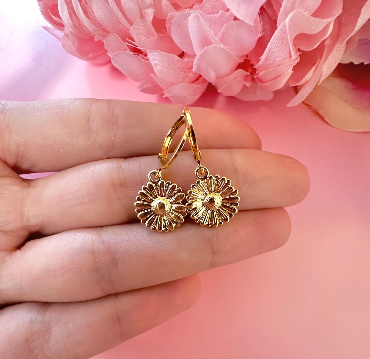 Gold Daisy Huggie earrings.