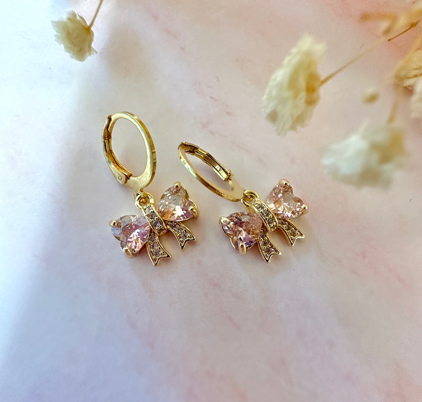 Pink CZ Bow gold huggie hoop earrings.