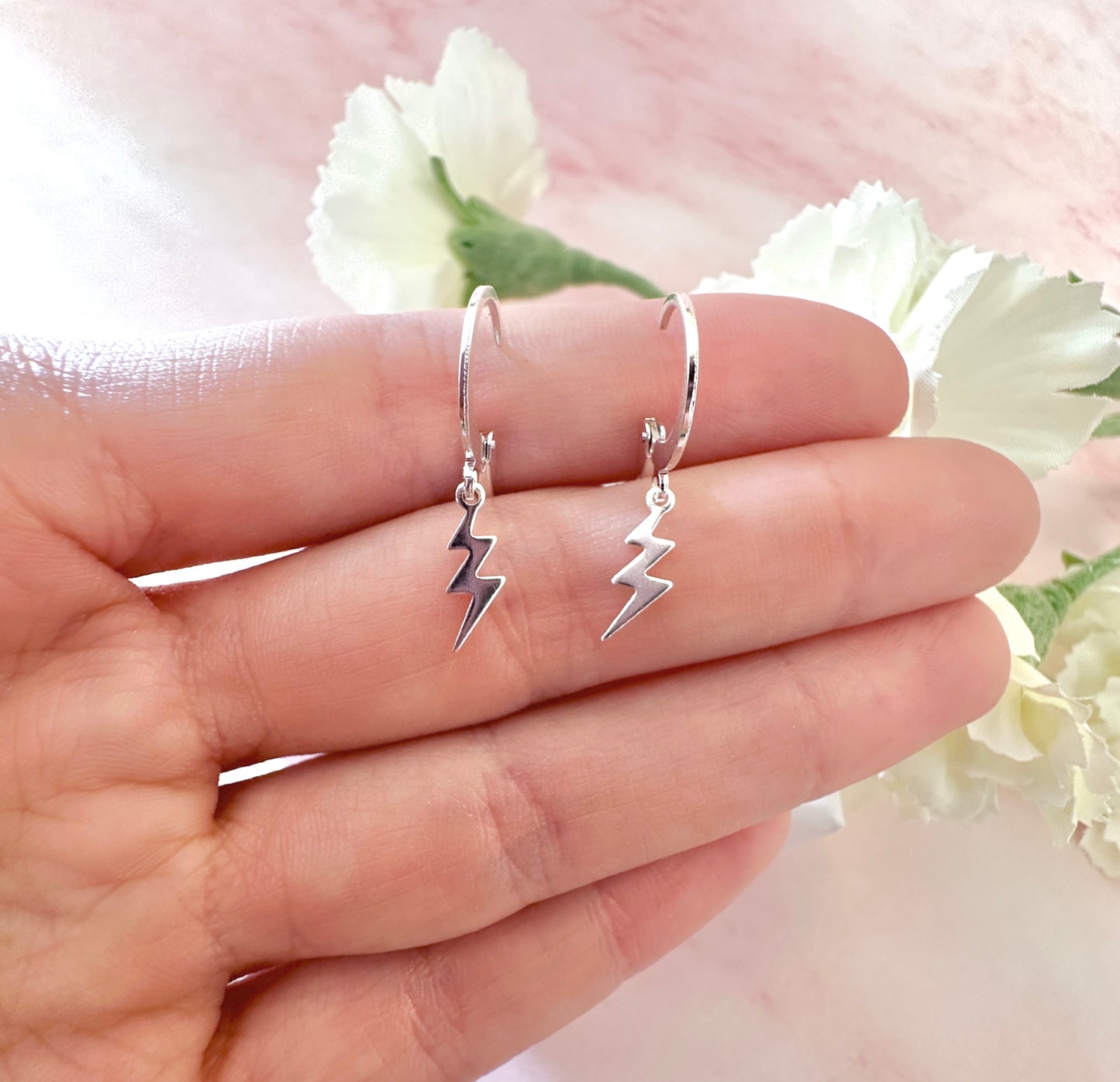 Tiny Silver Lightning Bolt huggie hoop earrings.